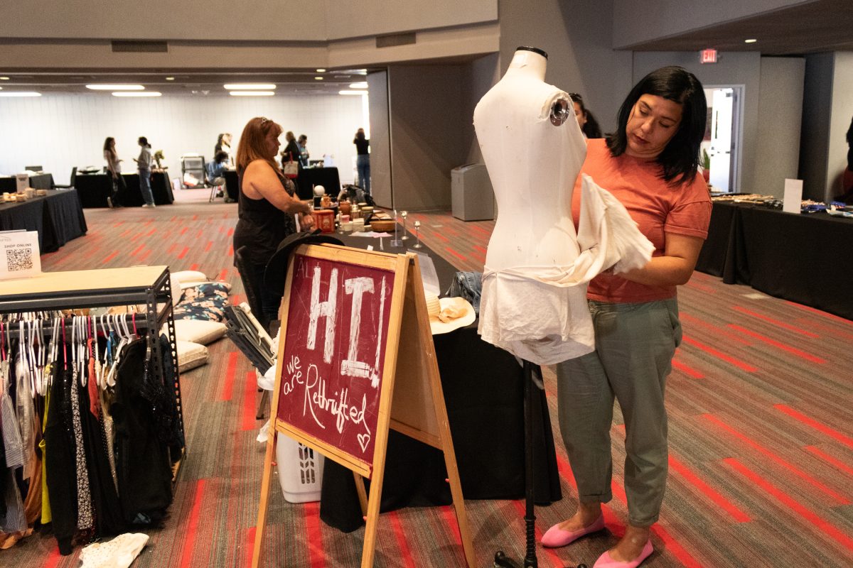 Iva Andrade, the director of sales for Rethrifted, changes the clothes on the dress form/mannequin inside the Northridge Center during the The Sustainable Fashion Expo on Monday, May 6, 2024. Andrade, Dre Lopez, and their team at Rethrifted won second place at the 9th annual Jeff Marine Bullring New Venture Competition on Wednesday, April 24, 2024.