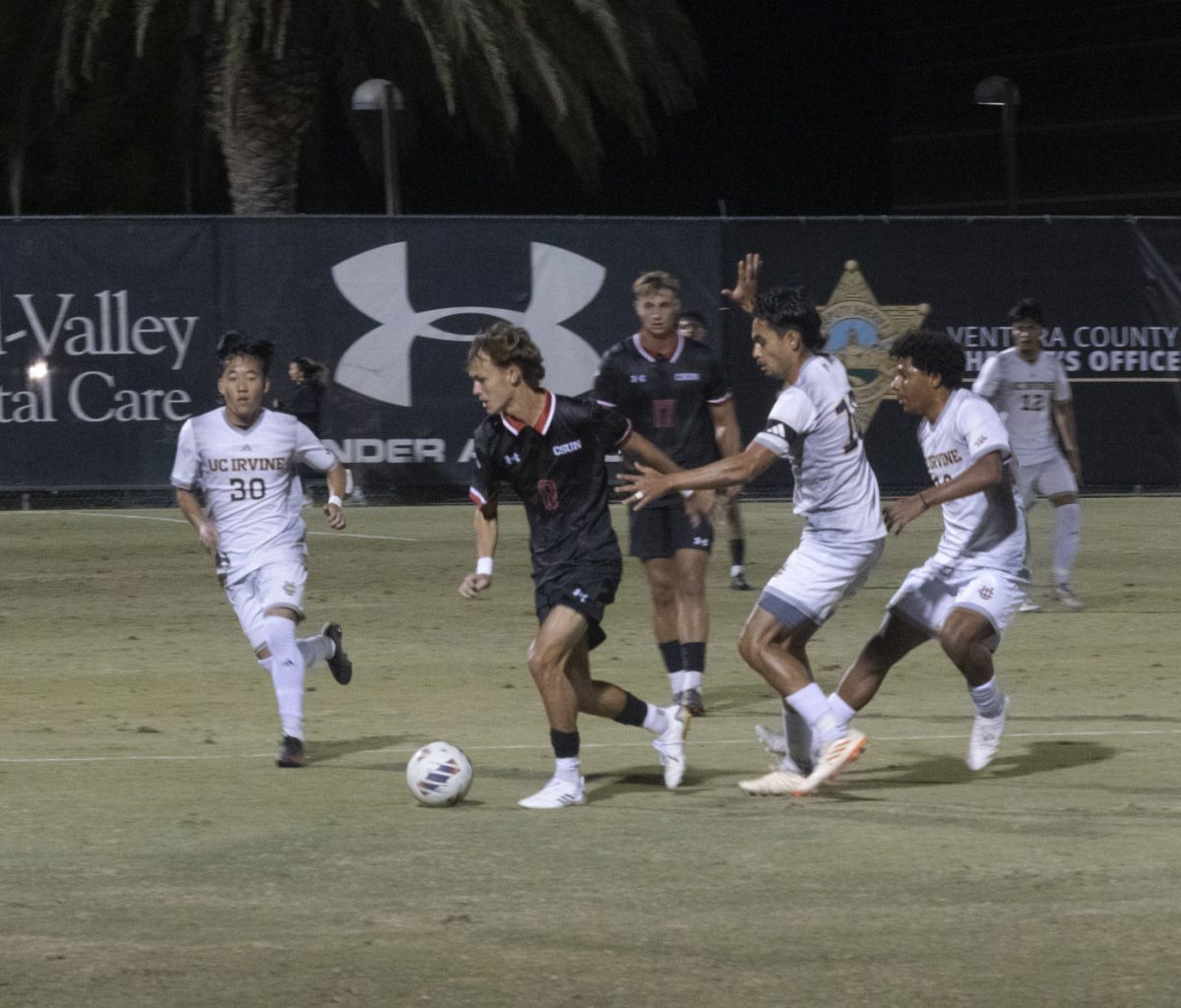 CSUN men's soccer midfielder Zack Harris, 8, dribbles the ball away from UC Irvine during their home match at the Performance Soccer Field on Saturday, Oct. 19, 2024.