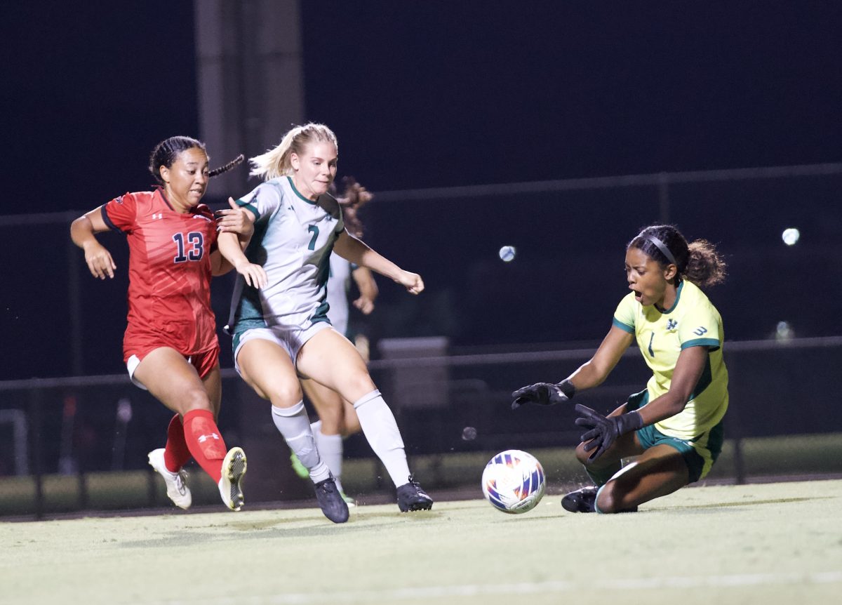 Hawaii Women’s Soccer goalkeeper Kennedy Justin claims the ball with her defender Eve Bleam, 7, blocking CSUN Women’s Soccer forward Cailey Jackson, 13, at the Matador Soccer Field on Oct. 3, 2024.