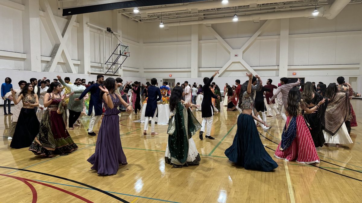 Students dance with joy, arms raised high during Garba Night 2024