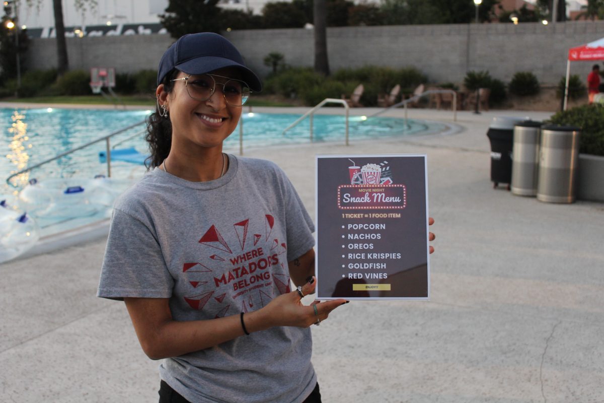 Aquatics supervisor, Mary Chavez, holding the event's snack menu at the Student Recreation Center's pool. 