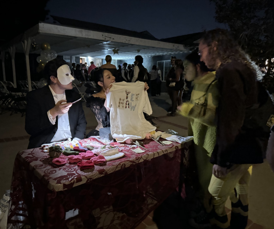 Acasola members selling handmade items at a table near the entrance of their Halloween event, Lost Sols.