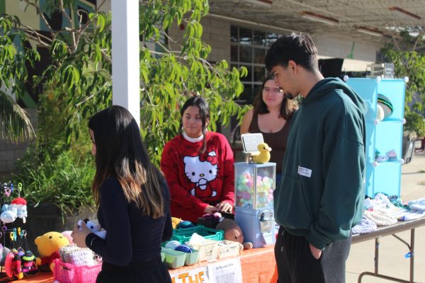 Ashley Ramirez, president of In the Loop knitting and crochet club, helping customers at the Holiday Sale on Dec. 3