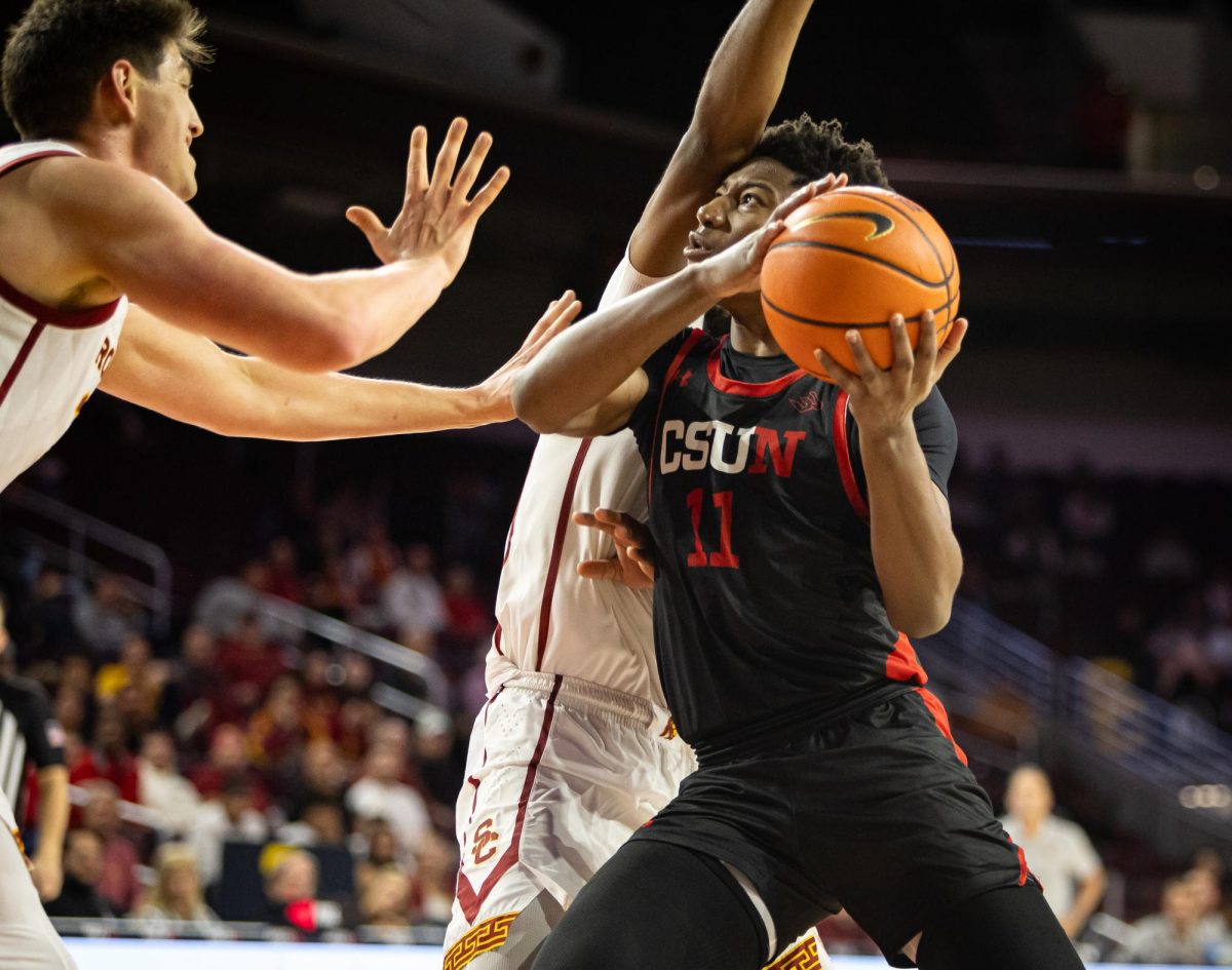 Matador forward Mahmoud Fofana, 11, drives to the basket for a layup while being defended by USC Trojan players at the Galen Center in Los Angeles, Calif., on Wednesday, Dec. 18, 2024.