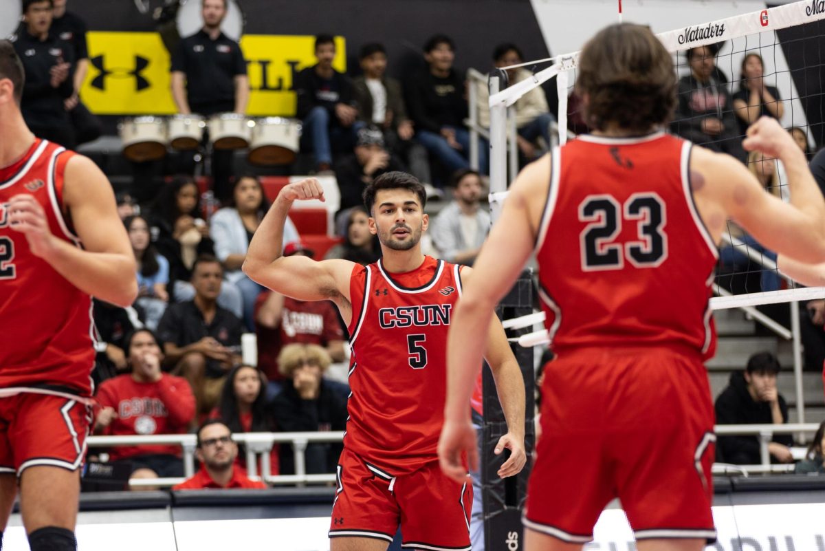 Outside hitter Joao Avila, 5, puts up his arm showing his muscle after scoring against UCLA and setter Donovan Constable, 23, also lifts his arm to celebrate on Friday, Jan. 24, 2025, at the Premier America Credit Union Arena in Northridge, Calif.