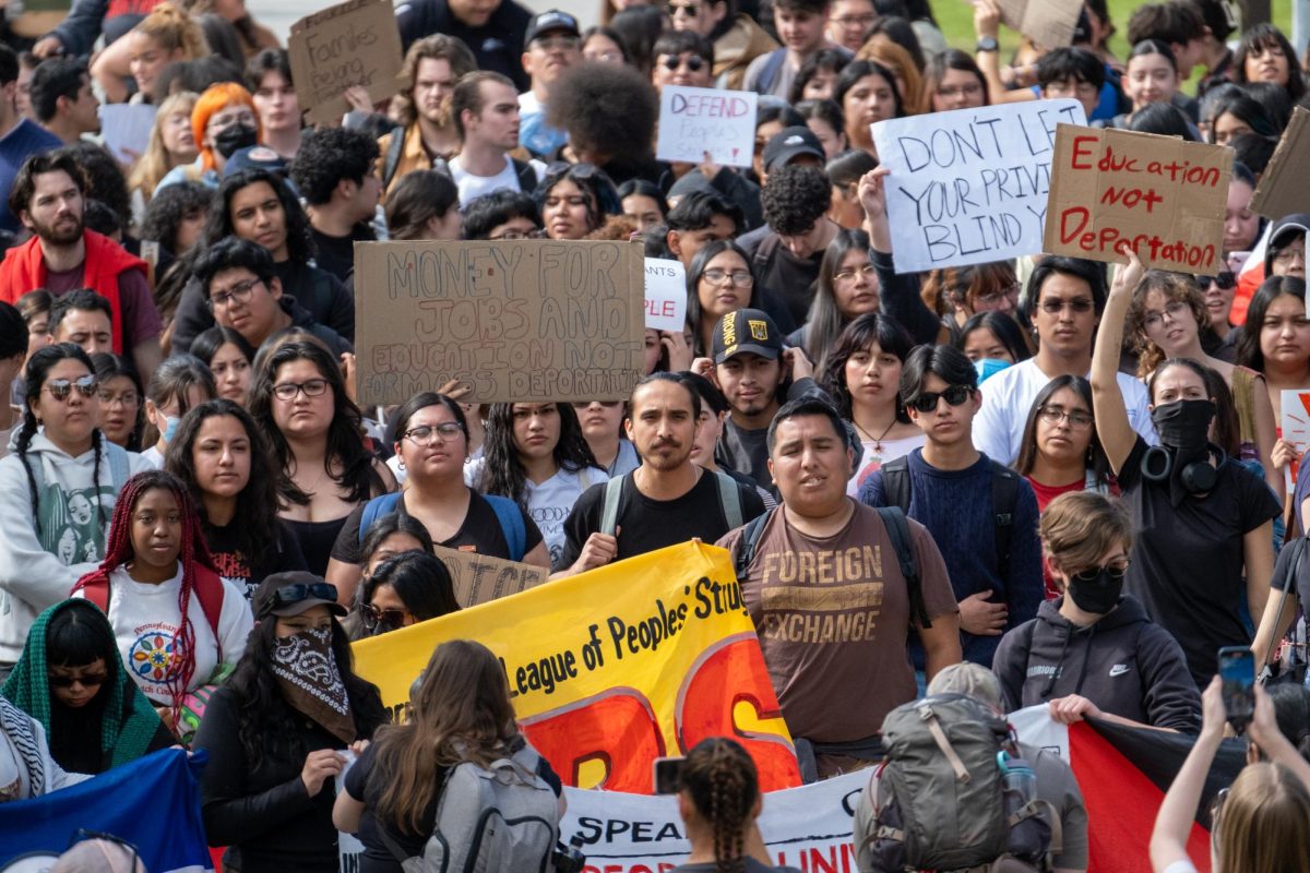 A crowd of protesters march down Matador Walk from the library on Wednesday, Feb. 19, 2025, in Northridge, California.