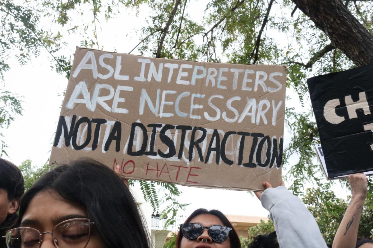 A student holds a sign that says "ASL interpreters are necessary, not a distraction No Hate" during the Charlie Kirk visit to campus in Northridge, Calif., on Thursday, March 6, 2025.