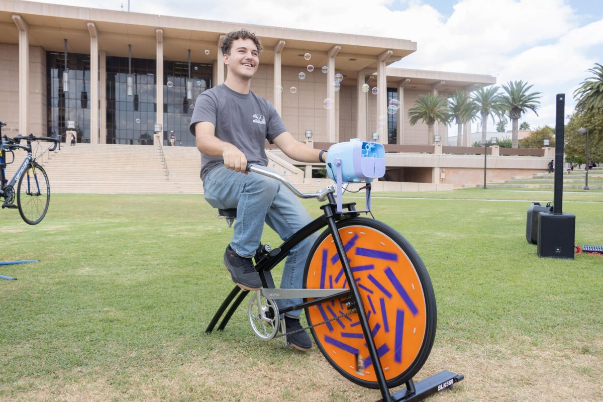 Dale McCann powers a bubble-making stationary bike at the Clean Air Day Pimp My Ride event on September 10 at California State University, Northridge. 

