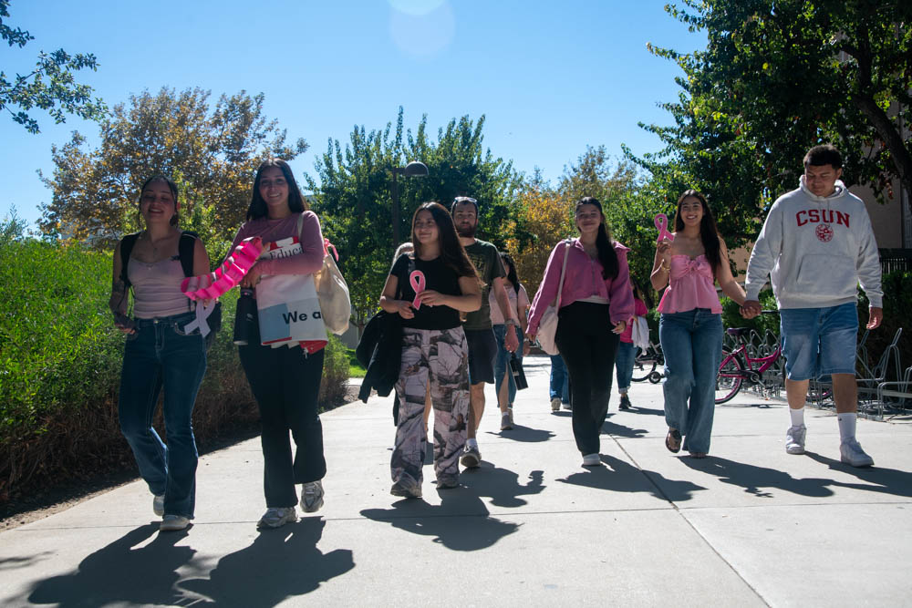 HESO members and fellow attendees smiling as they walk during the Breast Cancer Awareness Walk at CSUN on Oct. 20, 2025.