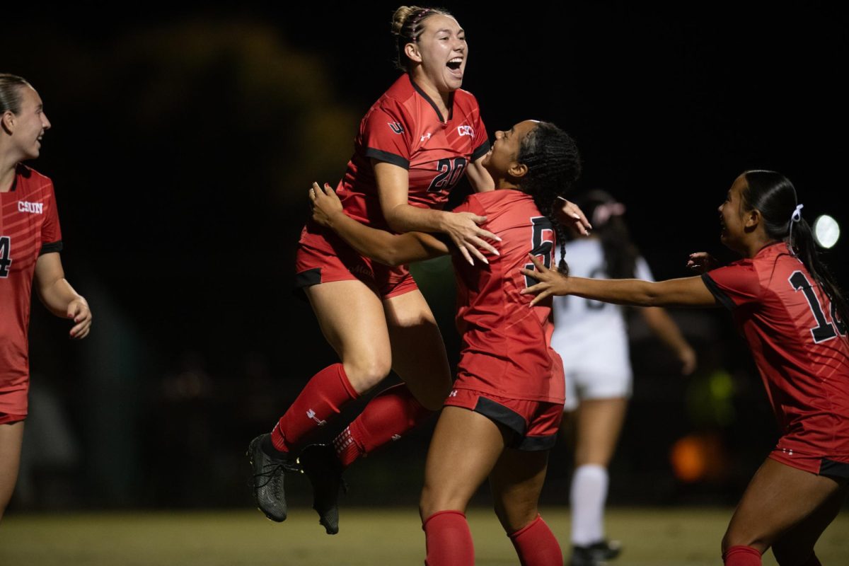 Lia Peterson (20) jumps onto Cailey Jackson (5) after scoring during a game against Long Beach State at Matador Soccer Field on Oct. 03, 2025.