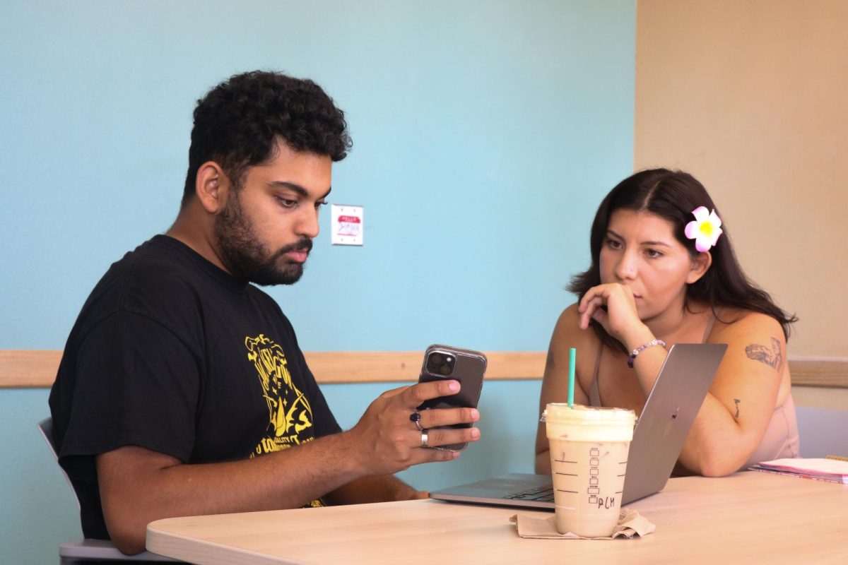 Inkiad Kabir sitting with Derenice Chavez as they read comments on Kabir's TikTok post sharing the Change.org petition at the University Library on Sept. 30, 2025, in Northridge, Calif. 