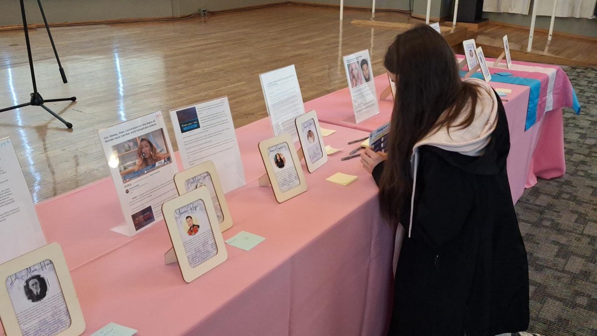 Student attendees write messages on sticky notes to the pictures on the altar dedicated to activists in the transgender community and those lost to transphobia this year at the CSUN Grand Salon at Northridge, Calif., on Nov. 20, 2025.