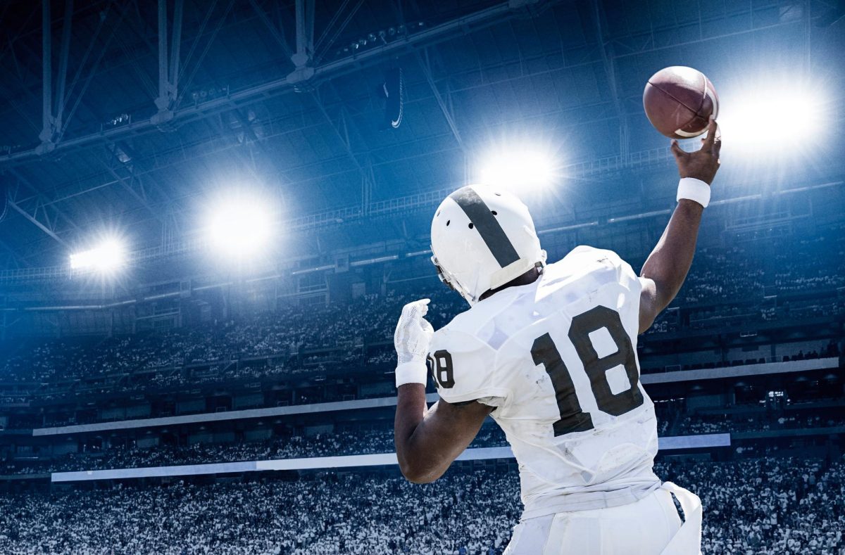 Quarterback throwing a football in a professional football game from Adobe Stock.