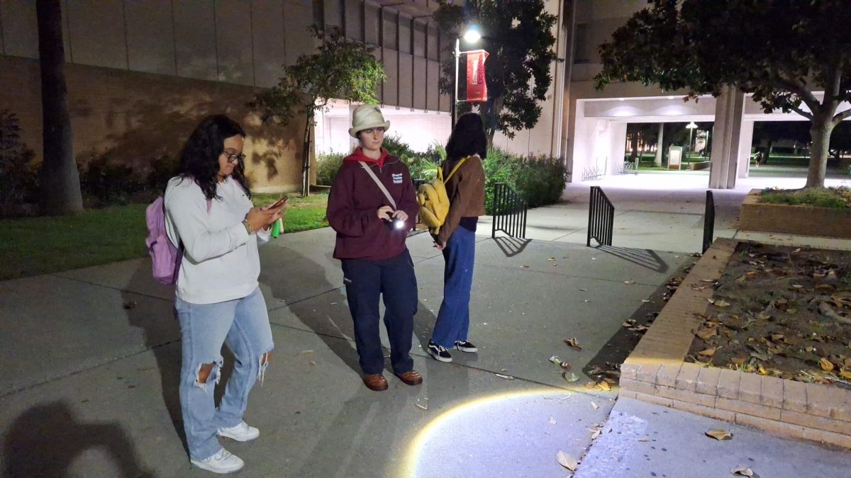 From left, Amelia Escalante, Cherish Williams and Bella Pulliam record their findings of an uneven sidewalk on the online form provided by the EHS. 