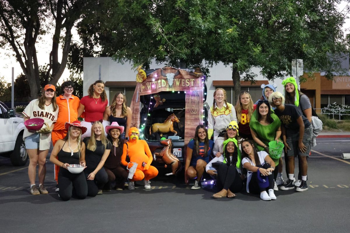 Athletes gather around their decorated car dressed up for the CSUN Student Athlete Advisory Committee trunk-or-treat in the Redwood Hall parking lot in Northridge, Calif., on Oct. 30, 2025. 