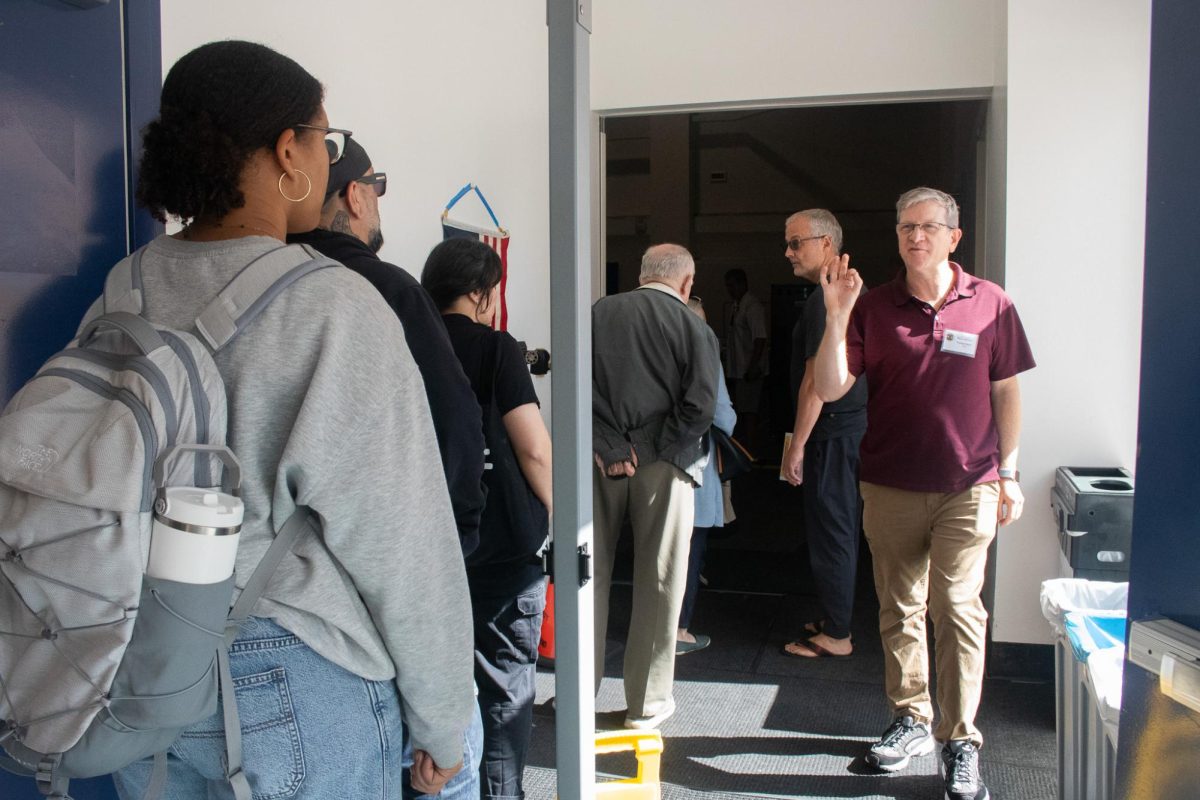 Tom N. addressing the line at CSUN's voting center outside of room 180 in Redwood Hall on Election Day in Northridge, Calif., on Nov. 4, 2025. 
