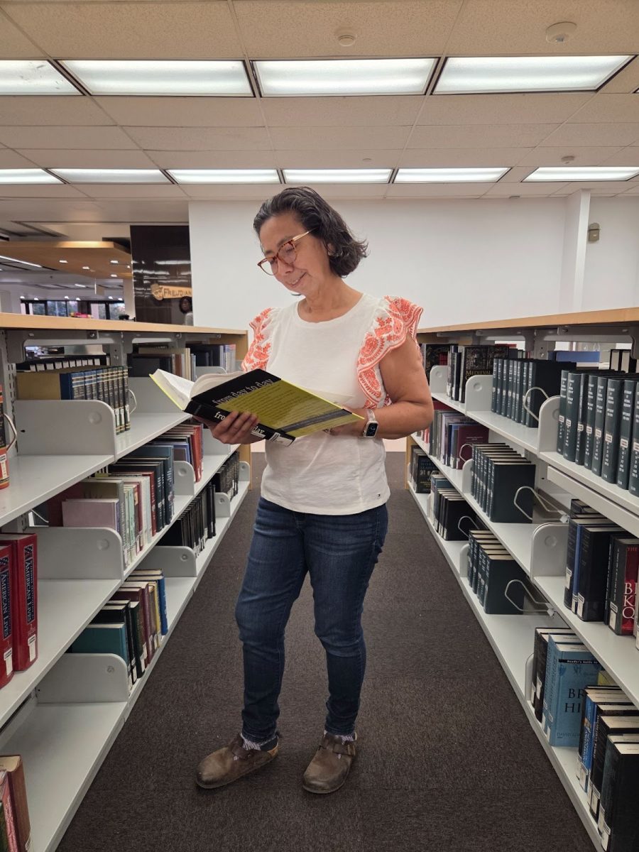 Cecilia Ordóñez lee un libro en el primer piso de la biblioteca de CSUN.