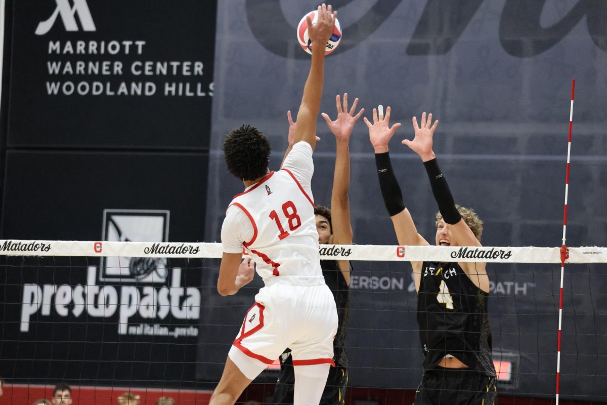 Jalen Phillips gets up high for a spike against two Long Beach defenders at the Premier America Credit Union Arena on March 27, 2026.
