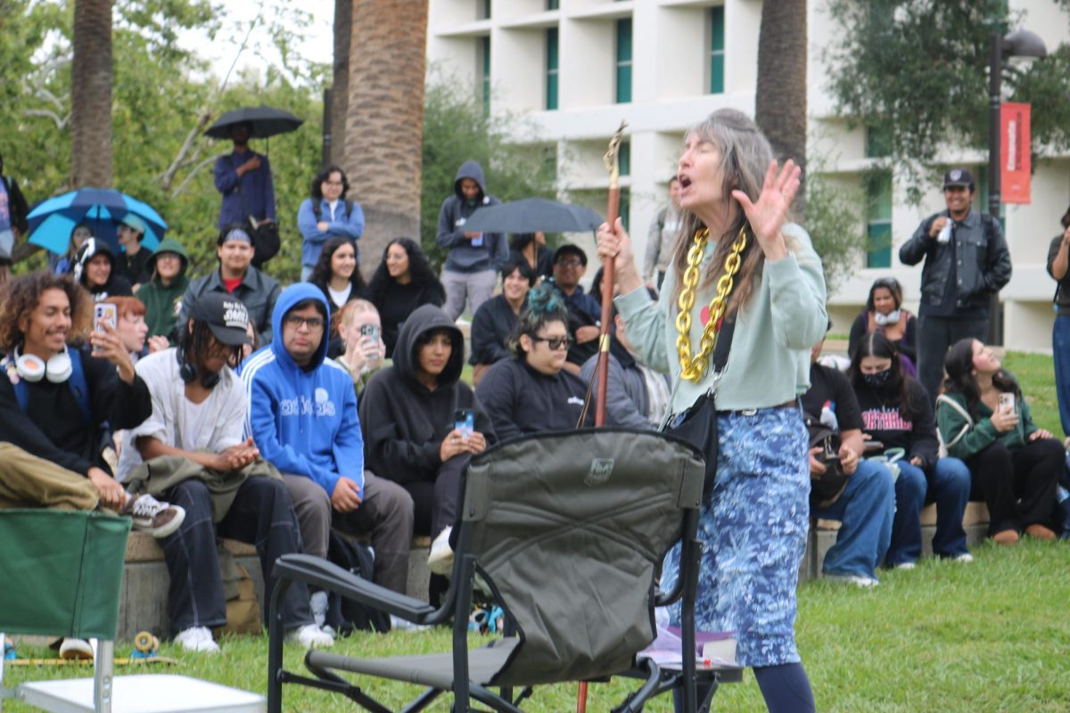 Sister Cindy holds her crucifix staff and wears her signature “Ho Chain” as she preaches to onlooking CSUN students on Tuesday, April 21, 2026.