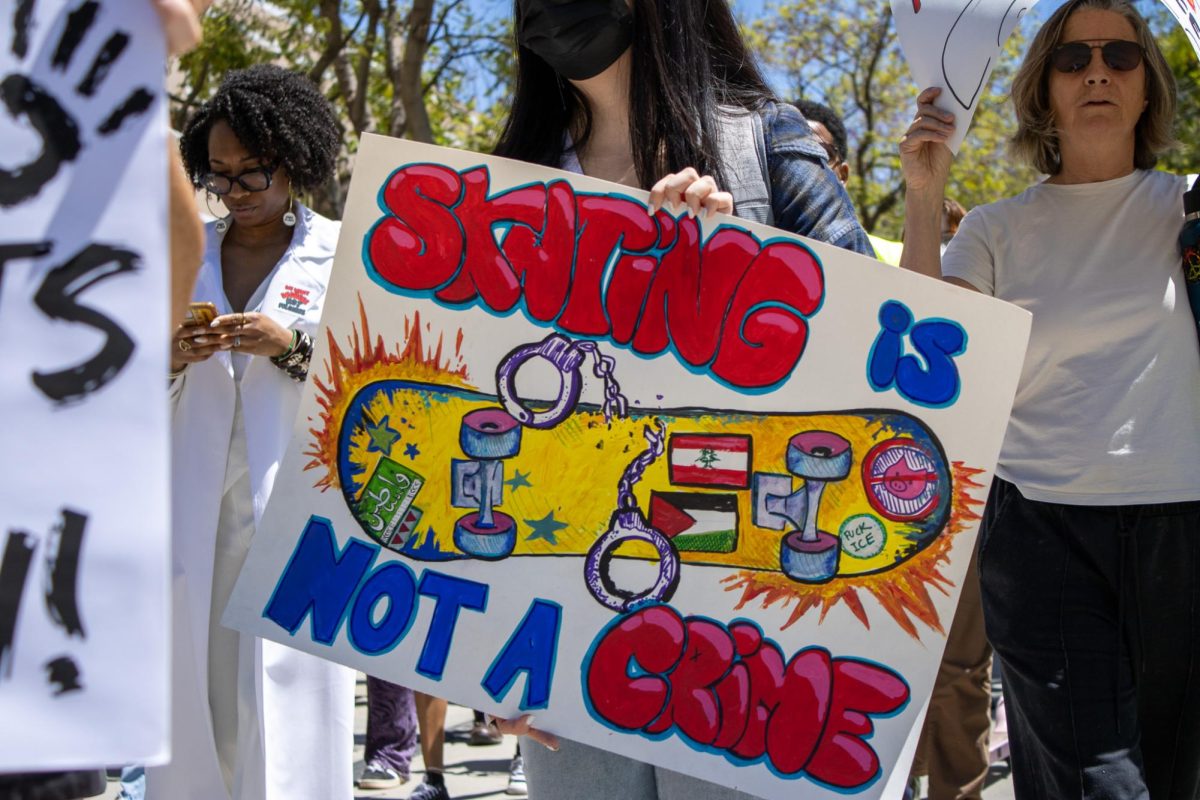 Estudiantes muestran una hoja con el mensaje “Patinar no es un crimen” en el Paseo de Jacarandá, en Northridge, California, el 23 de abril de 2026.
