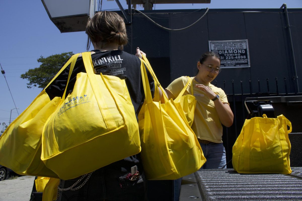 Volunteer Freddie Campbell helps carry in bags of food to The Offbeat bar in Highland Park, Los Angeles, Calif.