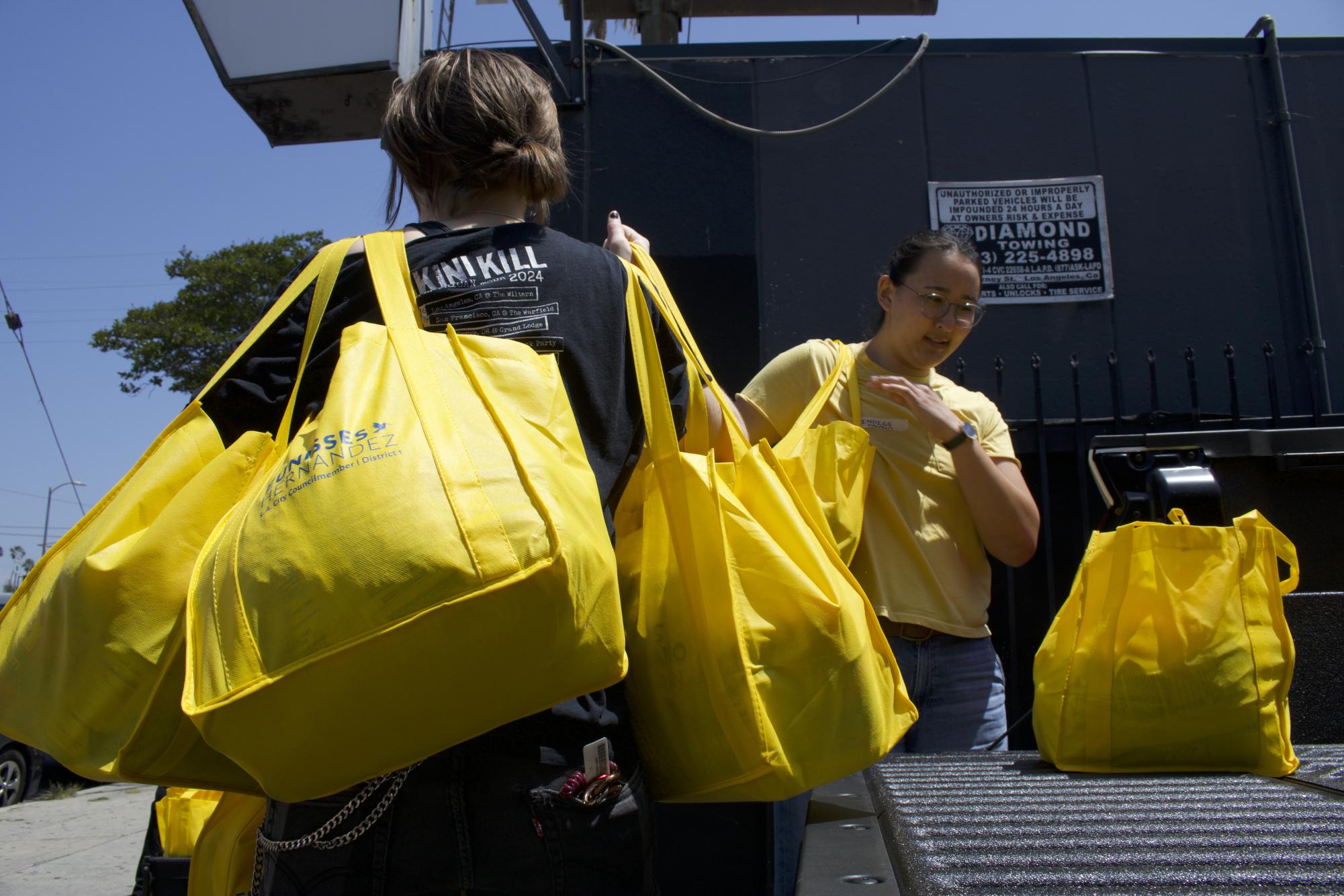 Volunteer Freddie Campbell helps carry in bags of food to The Offbeat bar in Highland Park, Los Angeles, Calif.