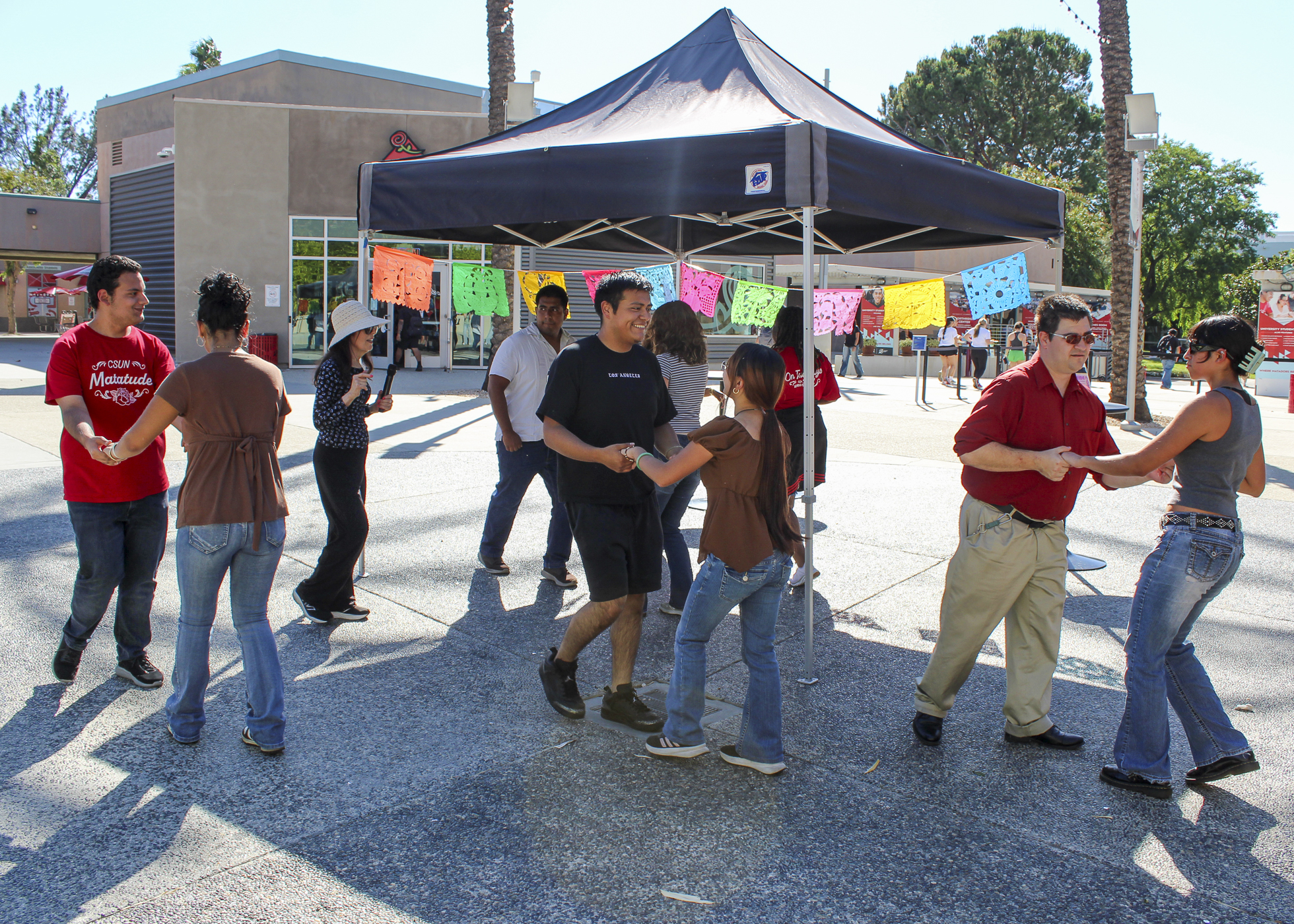 Students holding hands as they are ready to be taught bachata by Kinesiology Professor Jacqueline Eusanio during the Rhythm of Latinx Heritage Fiesta hosted by the University Student Union (USU) in Plaza del Sol, USU, on Sept. 29, 2026 in Northridge, Calif.